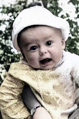 Bahar bahçesinde Panama şapkası takan küçük bir çocuğun klasik portresi. Retro fotoğraf, 1968.