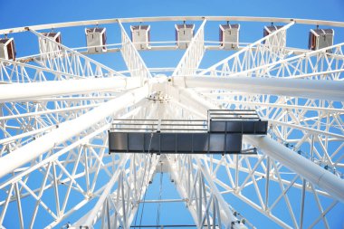 Gökyüzünde dönme dolap. Mavi arkaplanda beyaz görünüm çemberi
