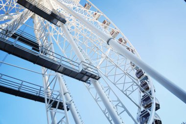 Gökyüzünde dönme dolap. Mavi arkaplanda beyaz görünüm çemberi