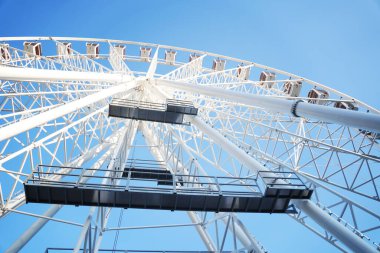 Gökyüzünde dönme dolap. Mavi arkaplanda beyaz görünüm çemberi