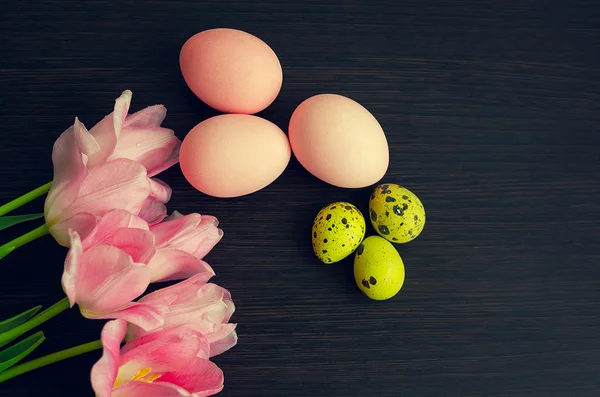 Easter background with colorful eggs and pink tulips