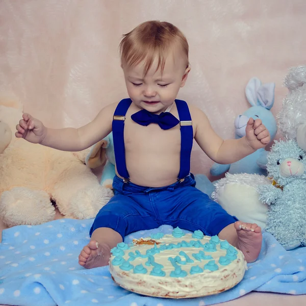 Menino chorando enquanto come seu bolo de festa de aniversário — Fotografia de Stock