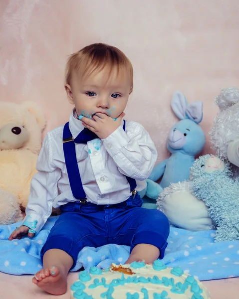 Menino feliz comendo bolo para sua primeira festa de aniversário — Fotografia de Stock