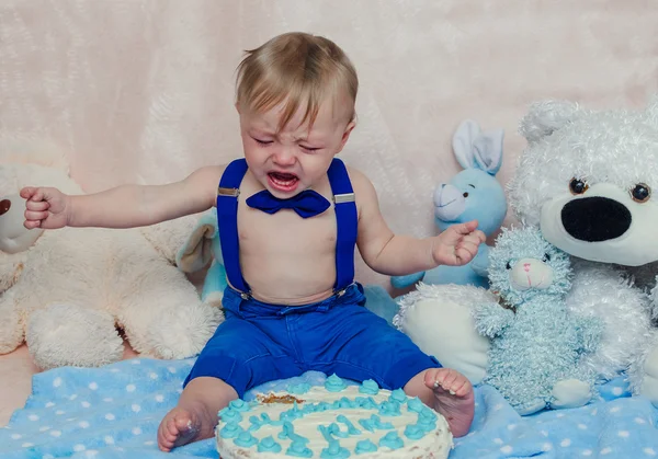 Menino chorando enquanto come seu bolo de festa de aniversário — Fotografia de Stock