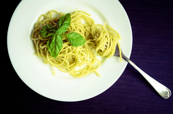 Esparguete de macarrão italiano com molho de pesto caseiro e folha de manjericão — Fotografia de Stock