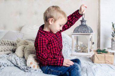 Noel zamanı kırmızı elbiseli küçük çocuk Noel ağacının yanında oynuyor. Tatil zamanı..