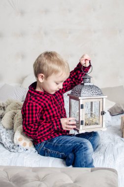 Noel zamanı kırmızı elbiseli küçük çocuk Noel ağacının yanında oynuyor. Tatil zamanı..