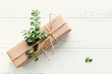 Modern Noel hediyeleri beyaz ahşap arka planda doğal dekor ile paketlenmiş. El sanatları kağıdında sicim ve yeşil dallarla kutular. Mevsimlik tebrik kartı. Üst Manzara. Düz yatıyordu. Boşluğu kopyala.