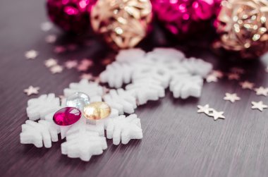 Pembe ve altın xmas baubles arka plan üzerinde beyaz kar taneleri.