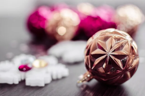 Gold christmas ball on bokeh background of xmas ornaments. — Stock Photo, Image