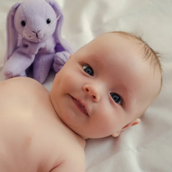 Naakte baby met een stuk speelgoed — Stockfoto
