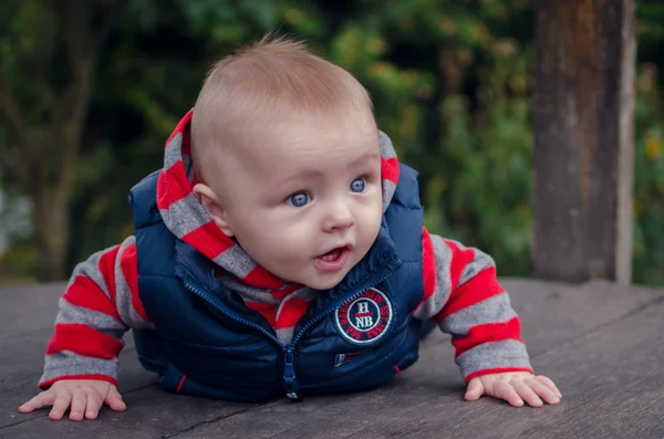 Babyjongen liggend op houten oppervlak — Stockfoto