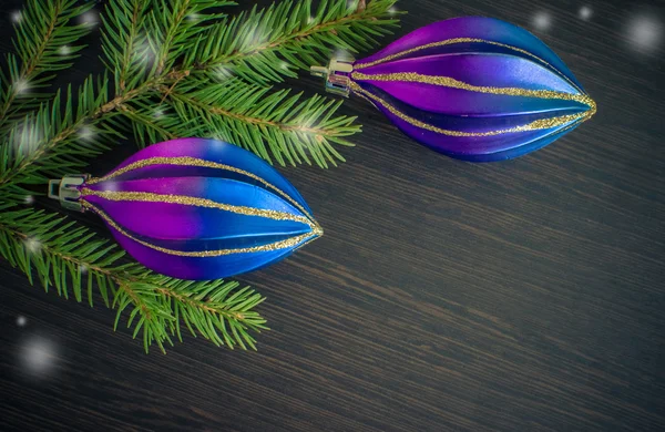Christmas fir tree and purple decoration on wooden board. — Stock Photo, Image