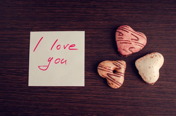 Nota Te amo con galletas sobre fondo de madera — Foto de Stock