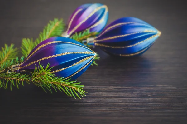 Christmas fir tree and purple decoration on wooden board. — Stock Photo, Image