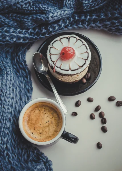 Bolo doce com uma cereja e xícara de café — Fotografia de Stock