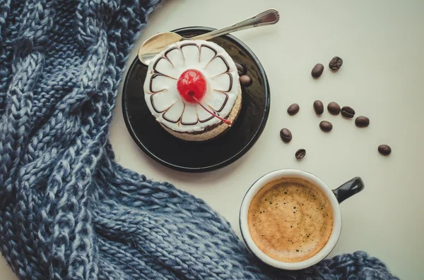 Sweet cake with a cherry and cup of coffee — Stock Photo, Image