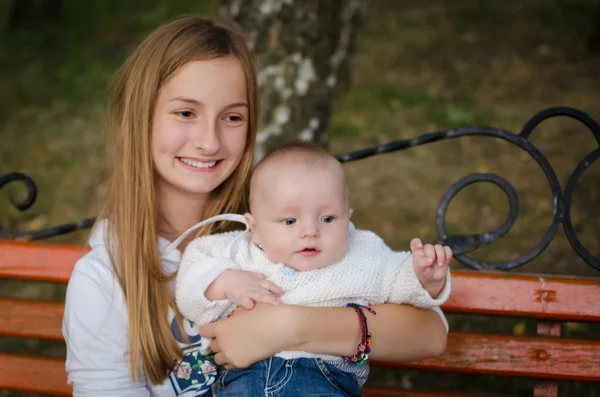 Teen sister holding her little baby brother — Stock Photo, Image