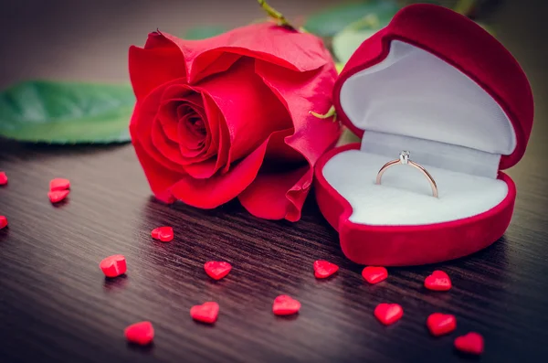 Червона оксамитова коробка, червона троянда і маленькі серця — стокове фото