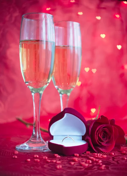Романтична обстановка з шампанським, трояндою та обручкою — стокове фото