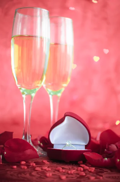 Натюрморт з шампанським, подарунковою коробкою та пелюстками червоної троянди — стокове фото