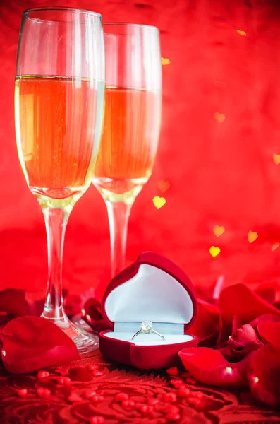 Valentines day background with champagne, ring and rose petals — Stock Photo, Image