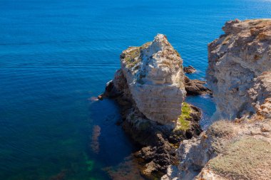 Yalnız bir kaya kıyıya yakın denizde duruyor.