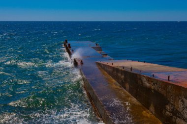 Deniz manzarası - dalgalar su sıçratarak metal iskeleye çarpar