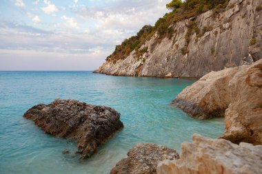 Deniz manzaralı kayalıklar turkuaz deniz suyuyla yıkanmış.