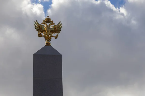 Coat of arms of Russia golden double-headed eagle at the top of the granite pyramid.