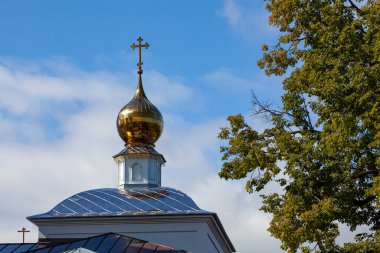 Mavi gökyüzüne karşı Ortodoks Kilisesi 'nin yaldızlı kubbesi ve haçı