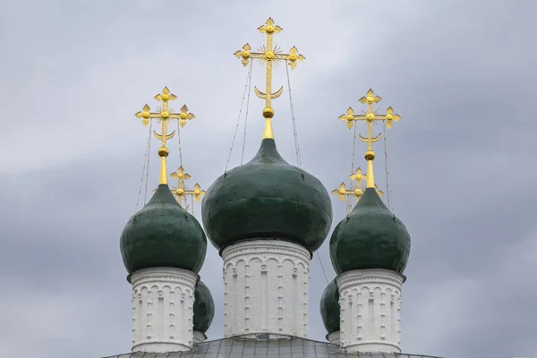 曇り空の背景に金色の十字架を持つ古代教会の暗い緑のドーム — ストック写真