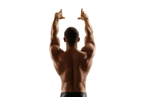 Uomo muscoloso in piedi con la schiena alzando le mani. Isolato . — Foto Stock