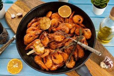 Kızartılmamış karides. Kır usulü kızartma tavasında servis edilmiş. Kızarmış sarımsak ve limon..