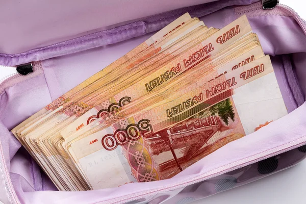 Women\'s cosmetic bag with a bundle of Russian money. Russian rubles with a nominal value of 5000. Criminal bribery.