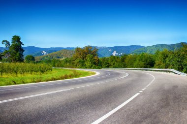 Dağlık arazideki yol, keskin virajlar. Yaz manzarası. Yılanlı yol. Asfalt kaplama. Doğal doğa..