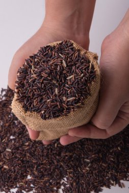 Üstten Görünüm tutan hads çuvallarda Riceberry pirinç.