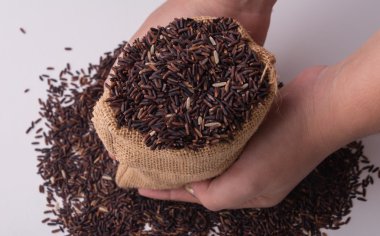 Üstten Görünüm tutan hads çuvallarda Riceberry pirinç.