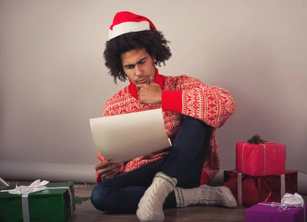 Portrait of young man with afro sitting at his room and preparing Christmas letter or wish list — Stock Photo, Image