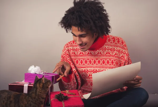 Retrato del joven con afro preparando carta de Navidad o lista de deseos —  Fotos de Stock