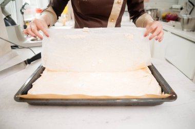 Kremalı pasta sarma işlemi. Pasta şefi kremalı pasta hazırlıyor. Mutfakta kremalı pasta yapıyorum. Çilekli krema ve rendelenmiş çikolata..