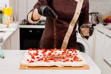 Kremalı pasta sarma işlemi. Pasta şefi kremalı pasta hazırlıyor. Mutfakta kremalı pasta yapıyorum. Çilekli krema ve rendelenmiş çikolata..