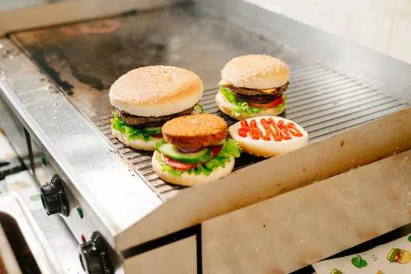 Burgers. The process of making burgers. The chef prepares burgers. Cooking burgers in the diner kitchen.