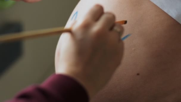 Una joven embarazada escribió en su estómago la palabra niño. Movimiento lento — Vídeo de stock