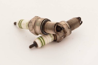 Used Spark Plug Set on White Background - Old Car Engine Ignition Parts