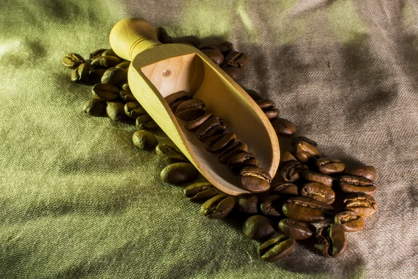 Cucharada de madera con granos de café — Foto de Stock