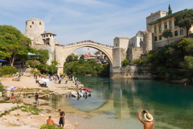 Genç bir adam Mostar 'daki tarihi Eski Köprü' den atlıyor. Bosna-Hersek. 20 Eylül 2018