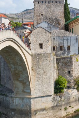 Genç bir adam Mostar 'daki tarihi Eski Köprü' den atlıyor. Bosna-Hersek. 20 Eylül 2018