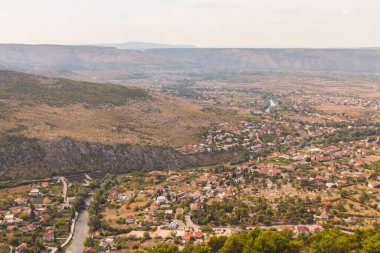 Güneşli bir günde Blagaj kasabasındaki dağın tepesinden manzarayı izleyin. Bosna-Hersek