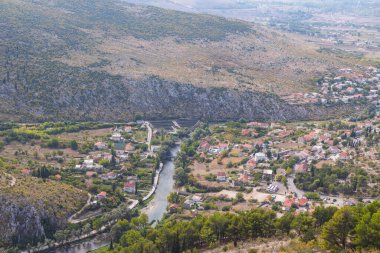 Güneşli bir günde Blagaj kasabasındaki dağın tepesinden manzarayı izleyin. Bosna-Hersek